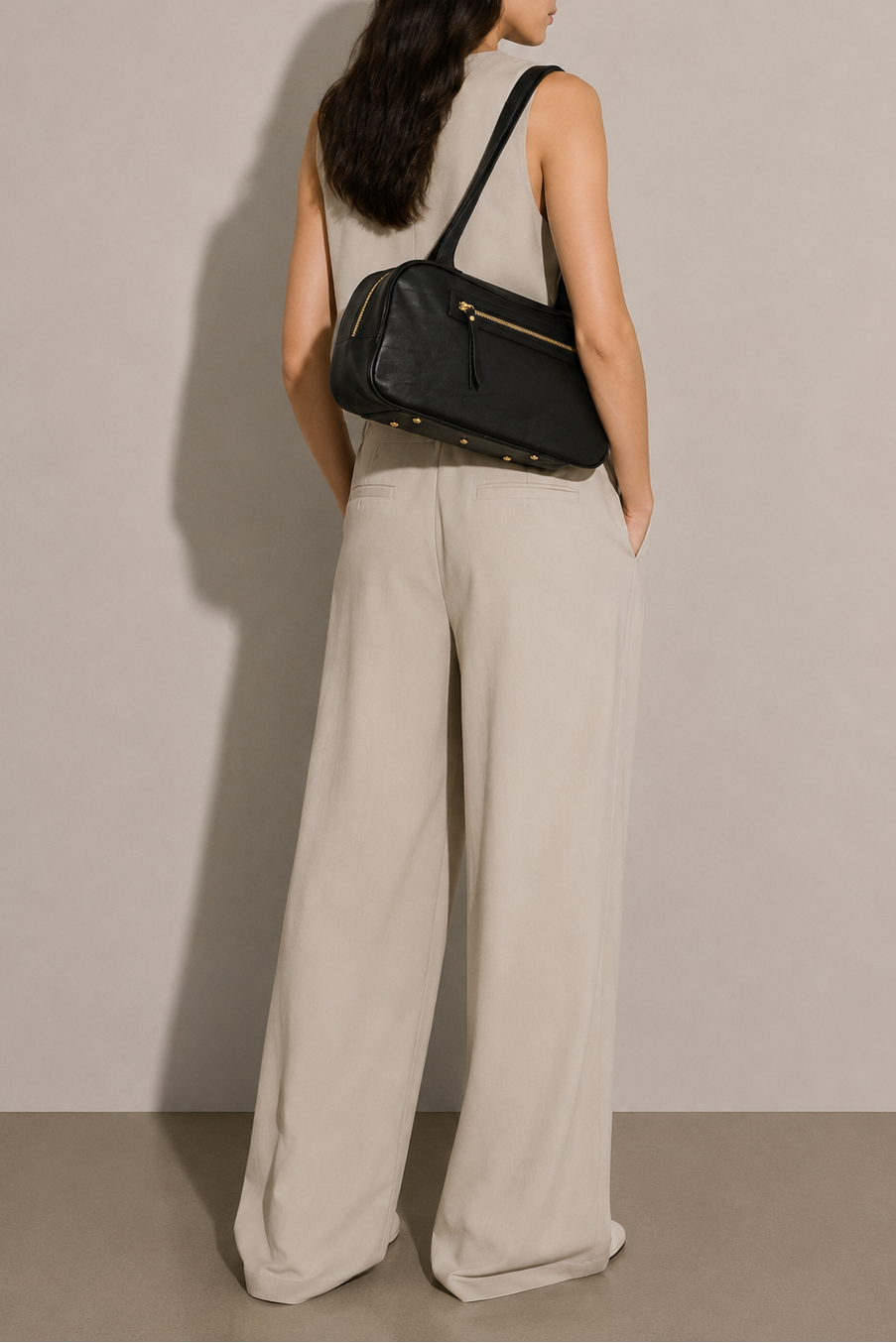 Black Leather Bowler bag on model. Gold hardware, zipper closure and should straps. 