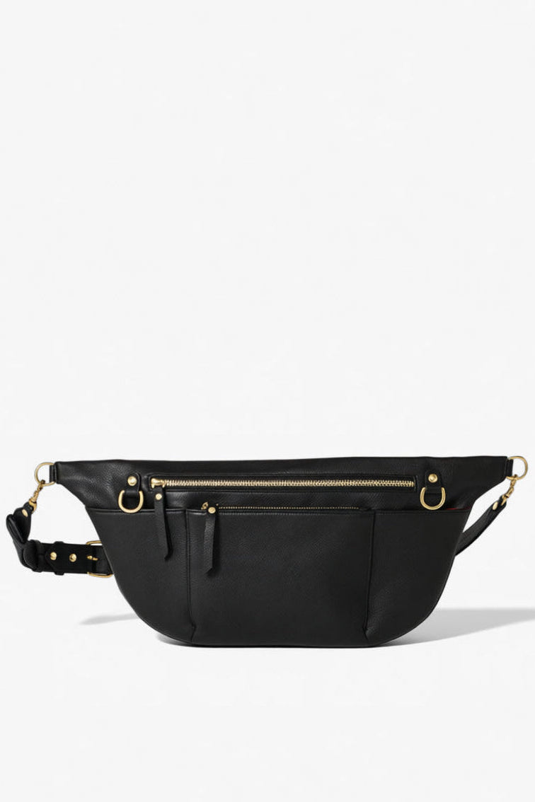 Black leather commuter sling bag with adjustable strap, zip compartments, and gold hardware, designed as a hands-free crossbody bag for work, travel, and everyday essentials.