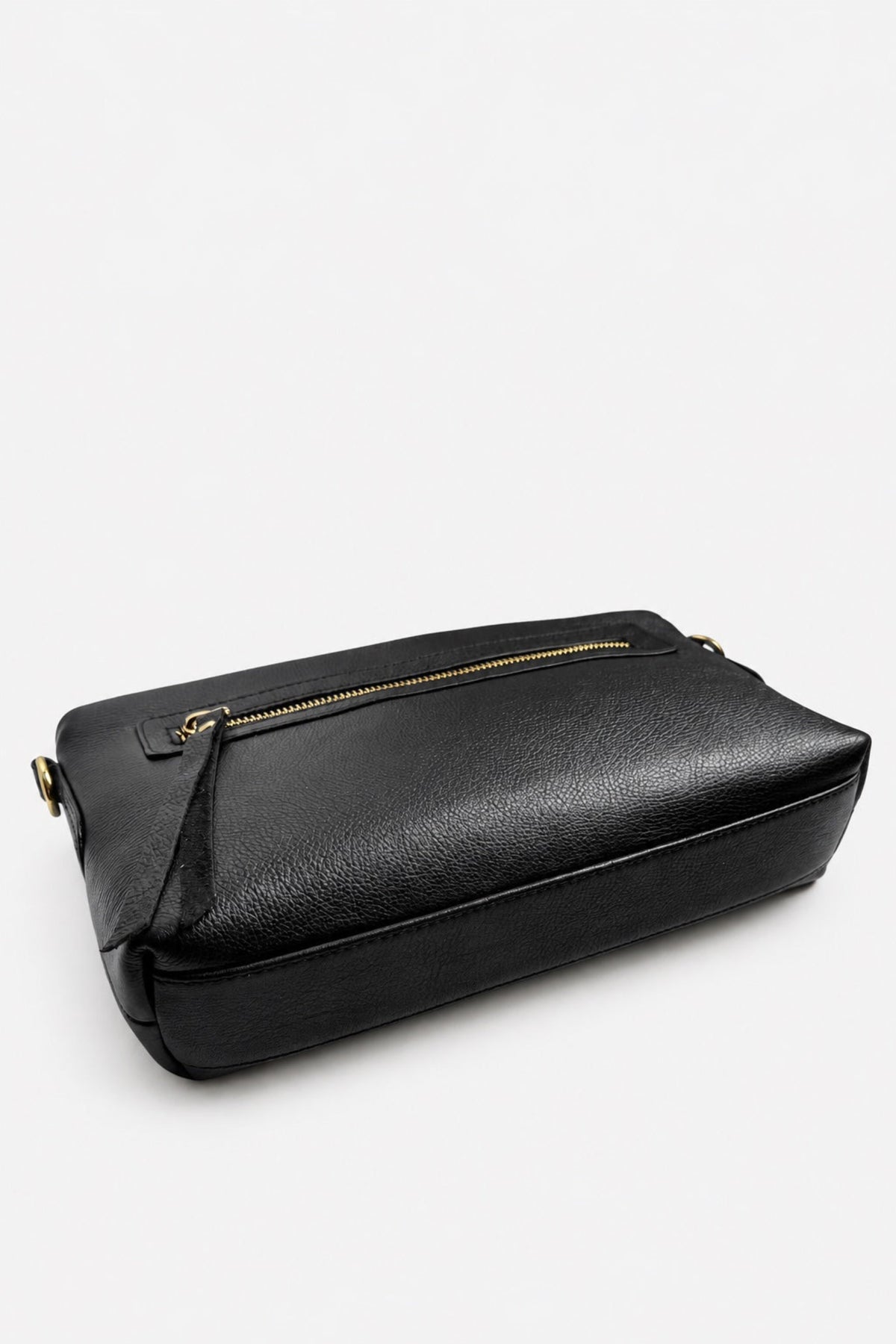 A black textured leather crossbody bag with a gold zipper and gold-tone hardware, photographed on a clean white studio background.