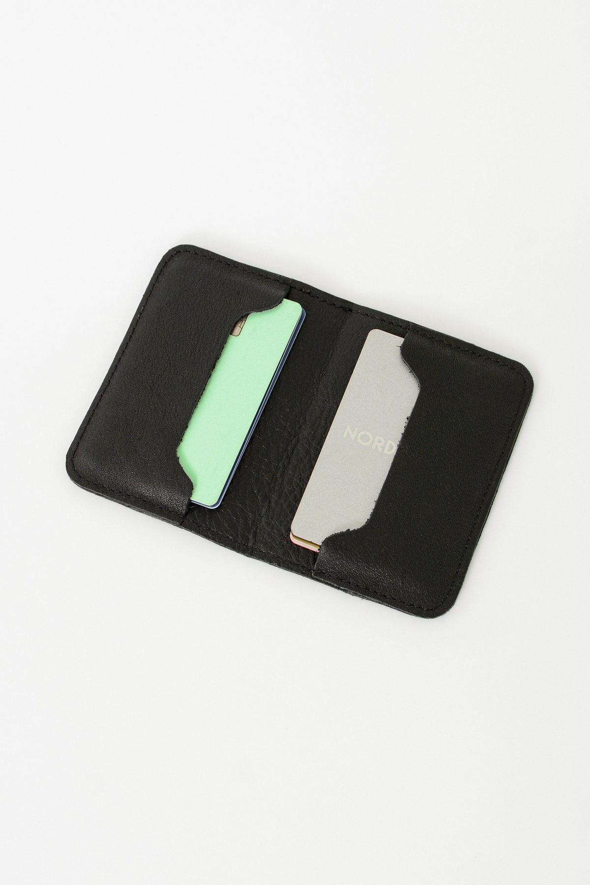 Fold over full grain leather wallet in the color black, a simple sleek design that holds up to 10 credit cards, and some cash