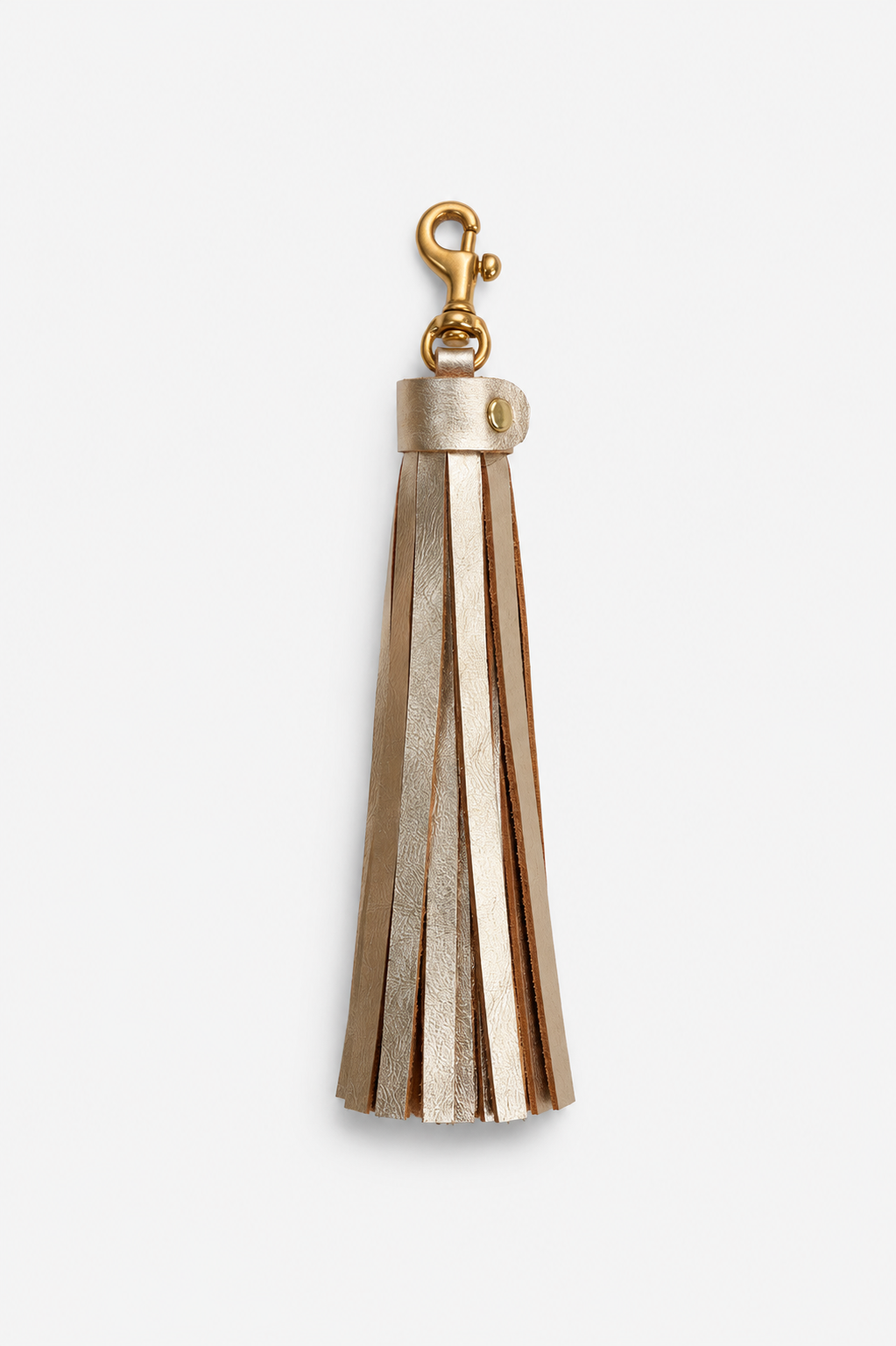 A gold-tone metal tassel keychain or bag charm with a lobster clasp, shown against a plain light gray background.