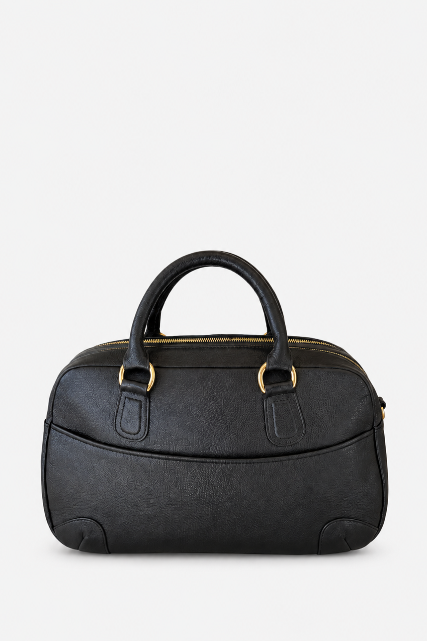 A black textured leather handbag with double top handles and gold-tone hardware, shown against a plain light gray background.