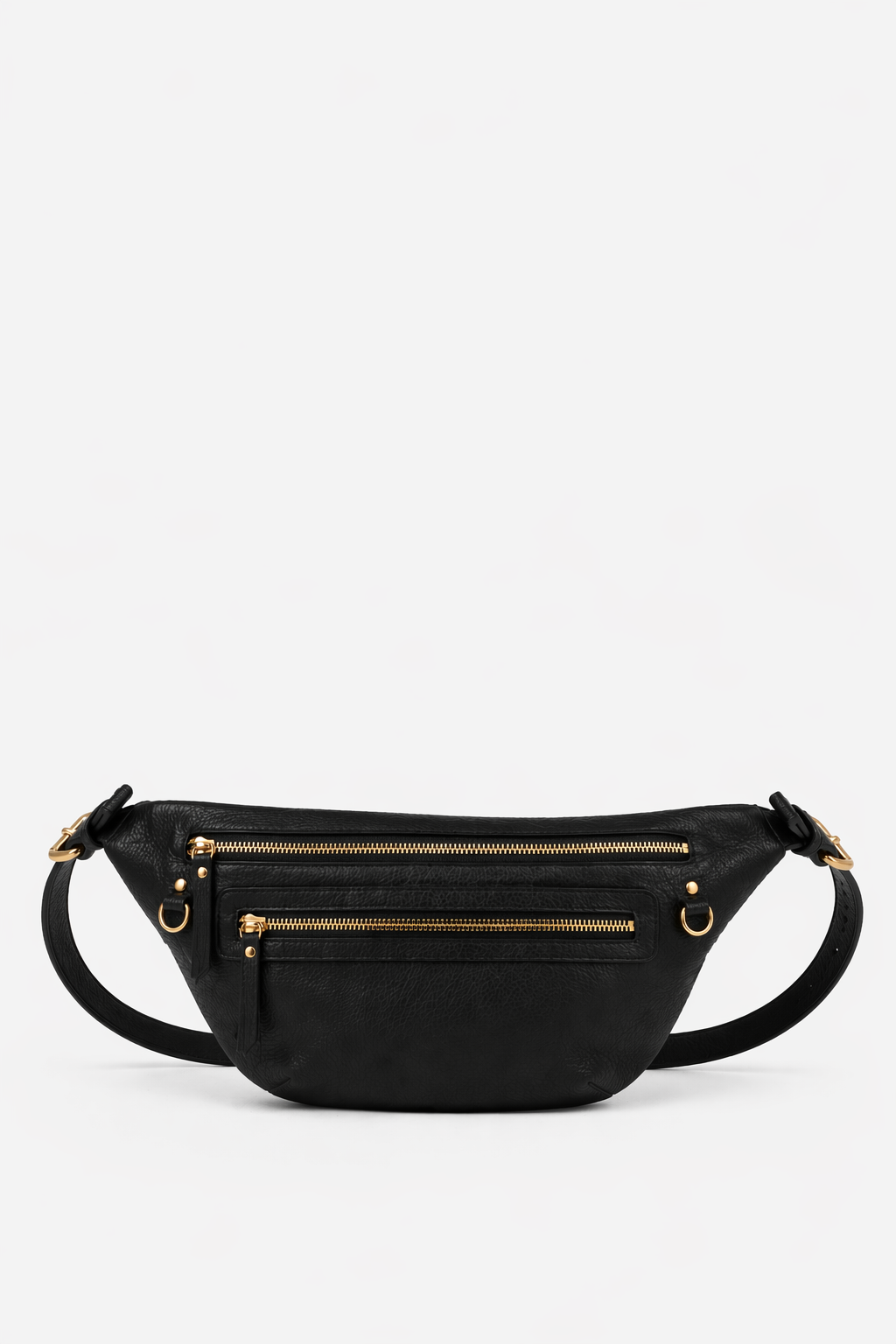 Black leather Nomad Carryall belt bag with adjustable strap, multiple zip compartments, and gold hardware, designed as a larger-capacity hands-free bag for travel, daily essentials, and on-the-go organization.
